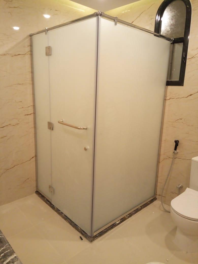 Frameless glass shower enclosure